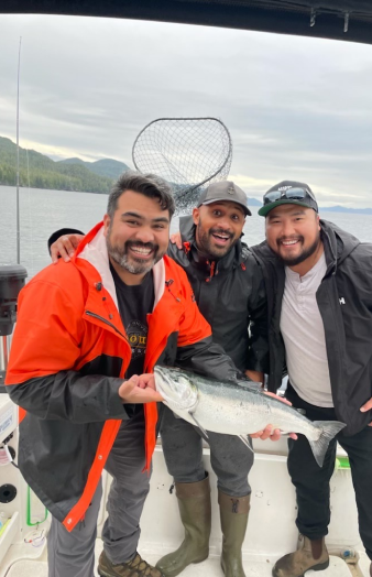 3 happy people holding the giant fish
